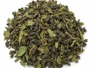 Barreja de te verd i fulles seques de menta a granel sobre fons blanc
